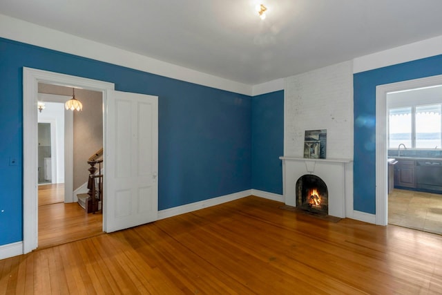 165 River Rd, Nyack, NY 10960 - unfurnished living room with hardwood / wood-style floors, a fireplace, and a chandelier