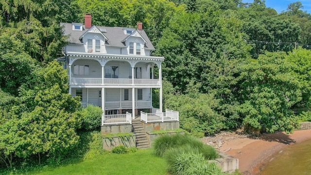 165 River Rd, Nyack, NY 10960 - rear view of house featuring a balcony, stairs, a chimney, a porch, and a wooded view