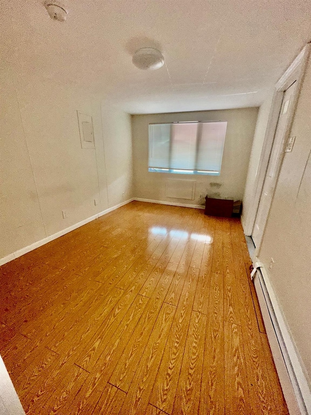 153-15 79th Ave, Flushing, NY 11367 - spare room with light wood-style flooring, baseboard heating, and a textured ceiling