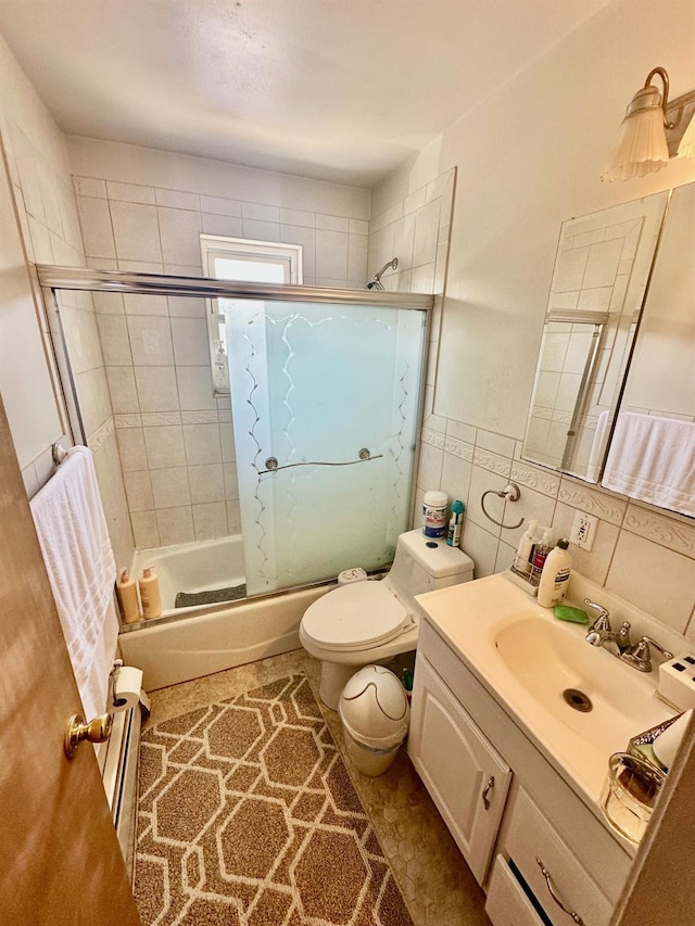 153-15 79th Ave, Flushing, NY 11367 - full bath featuring vanity, combined bath / shower with glass door, a baseboard radiator, and tile walls