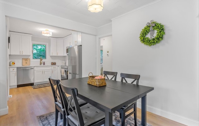 164 Maple Rd, Wading River, NY 11792 - dining area with light wood-style flooring and ornamental molding