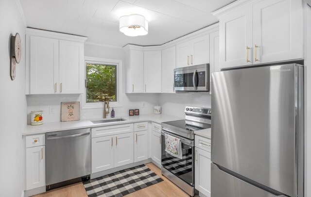 164 Maple Rd, Wading River, NY 11792 - kitchen with appliances with stainless steel finishes, light countertops, white cabinetry, and light wood-style flooring