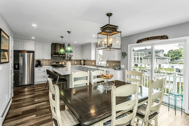10 Garfield Pl, Massapequa, NY 11758 - dining space with a baseboard heating unit, wood finished floors, recessed lighting, and a chandelier