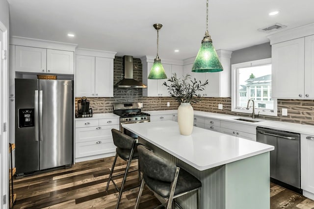 10 Garfield Pl, Massapequa, NY 11758 - kitchen featuring stainless steel appliances, wall chimney exhaust hood, dark wood-style floors, a kitchen island, and light countertops
