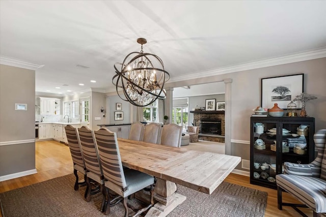 7 Westview Ln, Scarsdale, NY 10583 - dining room with a chandelier, light wood-style flooring, ornamental molding, a fireplace, and recessed lighting