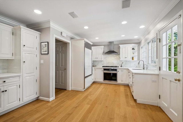 7 Westview Ln, Scarsdale, NY 10583 - kitchen featuring wall chimney exhaust hood, appliances with stainless steel finishes, light wood-type flooring, ornamental molding, and backsplash