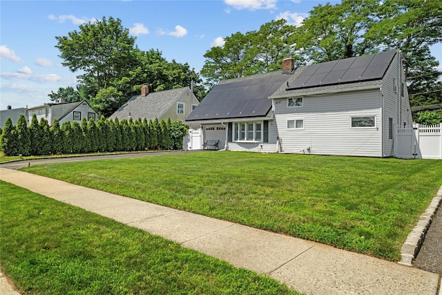 24 Border Ln, Levittown, NY 11756 - view of front of home with roof mounted solar panels, a garage, a gate, and a chimney