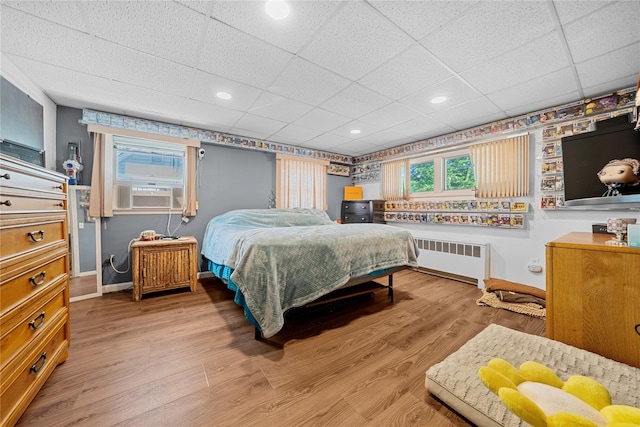 24 Border Ln, Levittown, NY 11756 - bedroom featuring radiator, cooling unit, a paneled ceiling, and wood finished floors