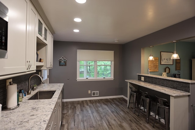 21 Edgebrook Ln, Airmont, NY 10952 - kitchen with white cabinetry, a kitchen bar, dark wood-style floors, light stone counters, and recessed lighting