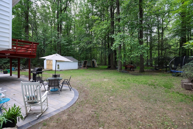 21 Edgebrook Ln, Airmont, NY 10952 - view of green lawn featuring a trampoline, a patio area, a storage unit, a wooden deck, and outdoor dining space