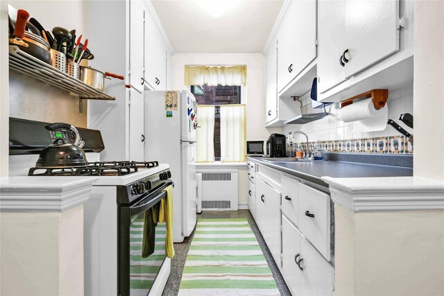84-51 Beverly Rd Unit 5P, Kew Gardens, NY 11415 - kitchen featuring radiator, gas stove, white cabinets, and freestanding refrigerator