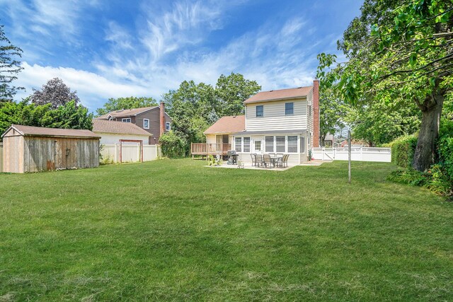 2772 Cypress Ave, East Meadow, NY 11554 - back of property featuring a storage shed, a chimney, a patio, and a fenced backyard