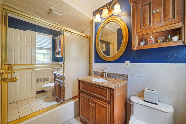 2772 Cypress Ave, East Meadow, NY 11554 - full bathroom featuring radiator, tile walls, vanity, tile patterned flooring, and tub / shower combination