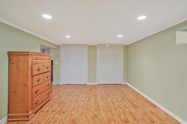 2772 Cypress Ave, East Meadow, NY 11554 - unfurnished bedroom featuring multiple closets, light wood-type flooring, crown molding, and recessed lighting