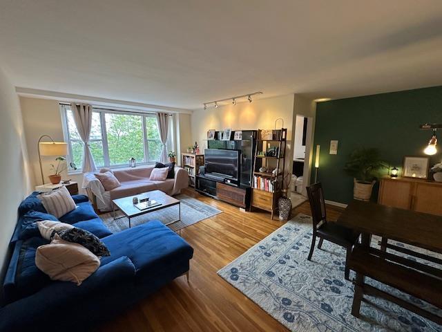 18-65 211th St Unit 5D, Bayside, NY 11360 - living room featuring wood finished floors and rail lighting