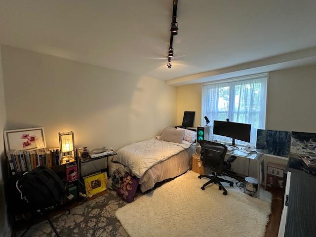 18-65 211th St Unit 5D, Bayside, NY 11360 - bedroom with rail lighting, a desk, and a ceiling fan
