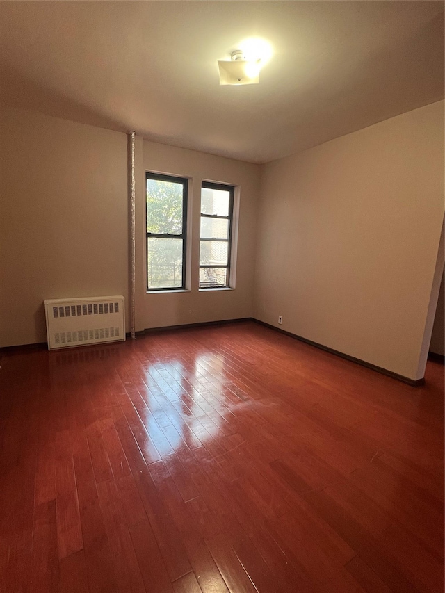 38-05 65th St Unit 2F, Woodside, NY 11377 - empty room with wood finished floors and radiator