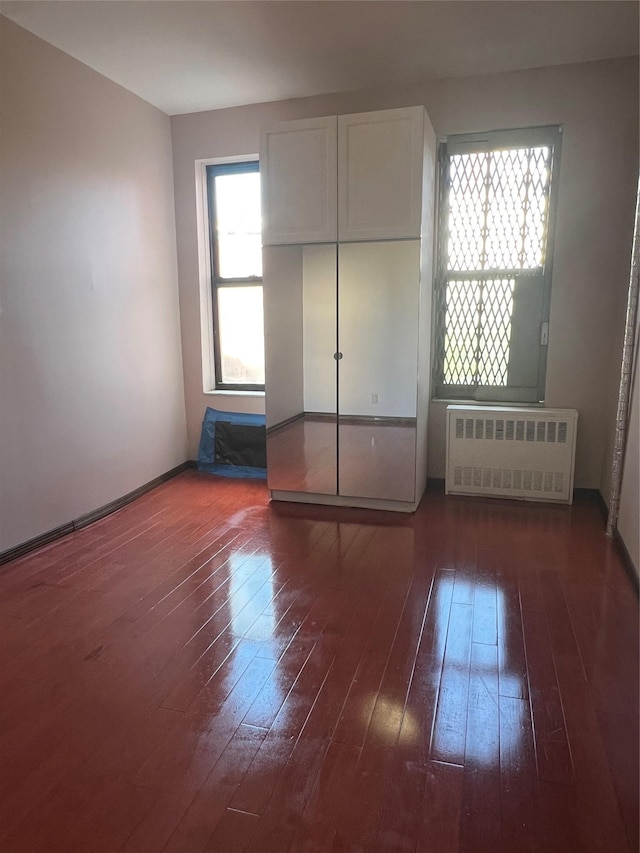 38-05 65th St Unit 2F, Woodside, NY 11377 - unfurnished bedroom with radiator and hardwood / wood-style floors