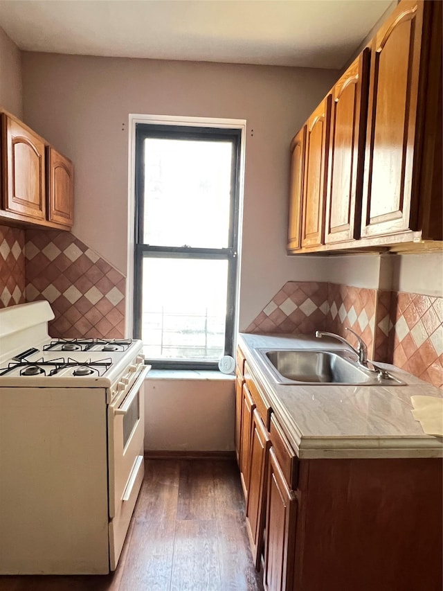 38-05 65th St Unit 2F, Woodside, NY 11377 - kitchen with white range with gas stovetop, wood-type flooring, light countertops, backsplash, and brown cabinets