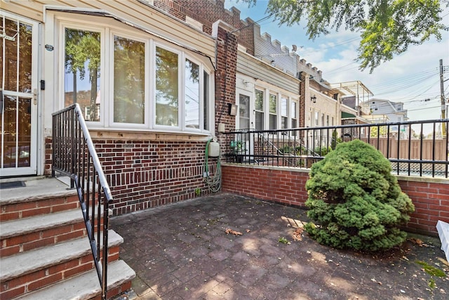 25-57 Mcintosh St, East Elmhurst, NY 11369 - property entrance with brick siding and a patio area