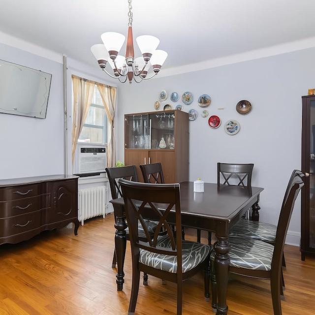 25-57 Mcintosh St, East Elmhurst, NY 11369 - dining area with radiator heating unit, a chandelier, cooling unit, and light wood-style floors