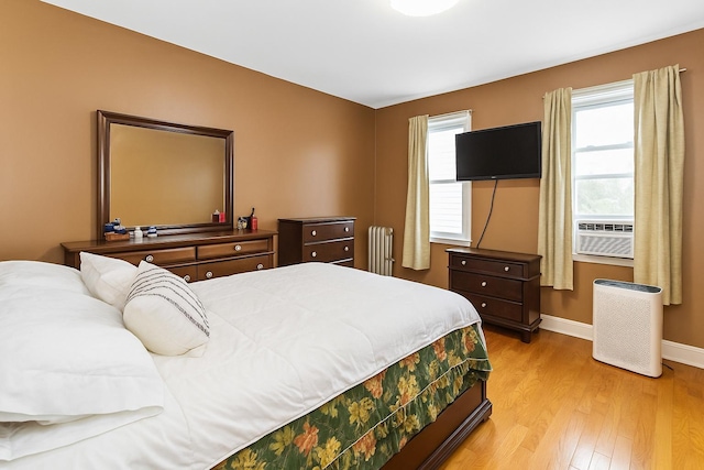 25-57 Mcintosh St, East Elmhurst, NY 11369 - bedroom with radiator, cooling unit, and light wood-style flooring
