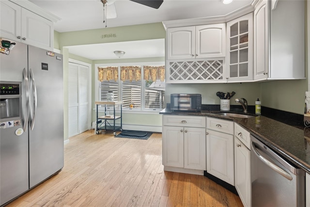 111 Little E Neck Rd, Babylon, NY 11702 - kitchen with appliances with stainless steel finishes, white cabinets, glass insert cabinets, dark stone counters, and a ceiling fan
