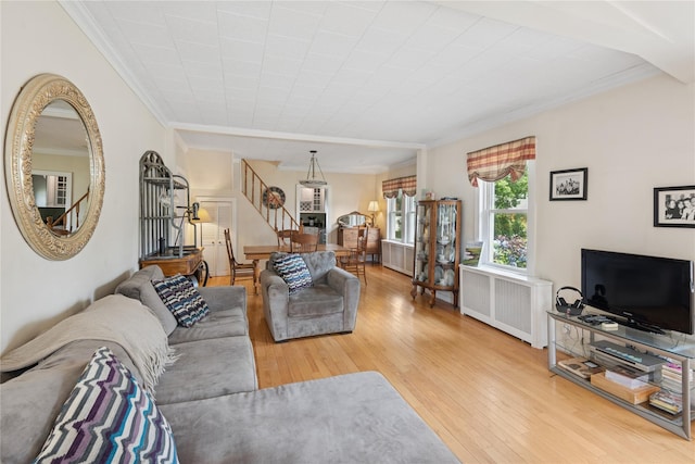 111 Little E Neck Rd, Babylon, NY 11702 - living room featuring crown molding, stairway, radiator heating unit, and hardwood / wood-style floors