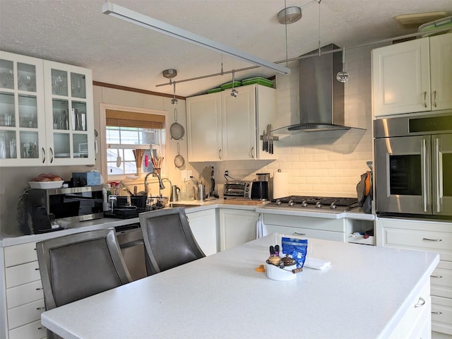 4 Treeline Cir Unit 4, Cold Spring, NY 10516 - kitchen featuring wall chimney range hood, stainless steel appliances, light countertops, a textured ceiling, and white cabinetry