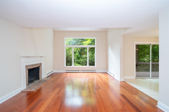 5 Grove Mews, Chappaqua, NY 10514 - unfurnished living room featuring healthy amount of natural light, hardwood / wood-style flooring, a fireplace, and a baseboard radiator