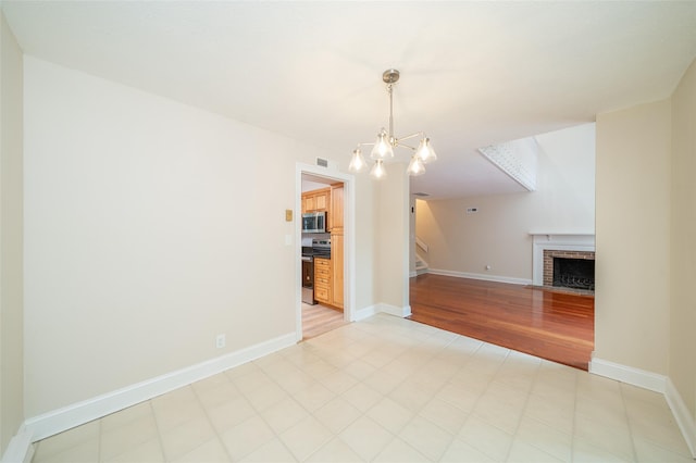 5 Grove Mews, Chappaqua, NY 10514 - unfurnished living room with a brick fireplace, a chandelier, and stairs