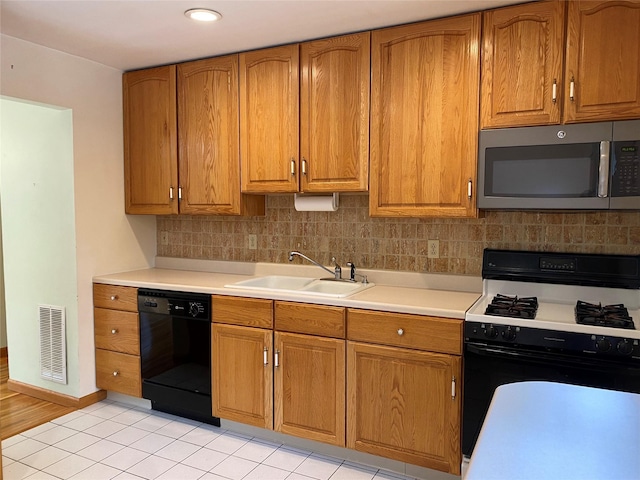 14 Shepard Rd, Warwick, NY 10990 - kitchen with black appliances, backsplash, light countertops, brown cabinetry, and light tile patterned flooring