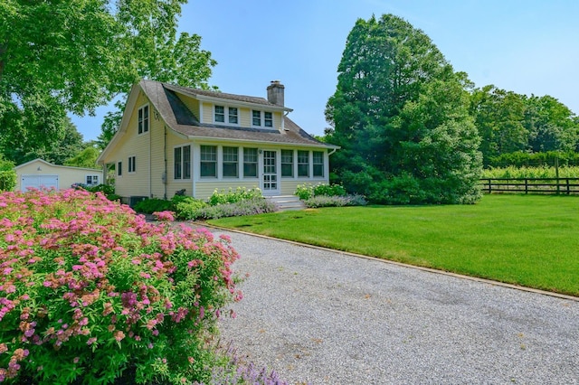 9780 Old Sound Ave, Mattituck, NY 11952 - view of front of house with a chimney, an outdoor structure, gravel driveway, and a detached garage