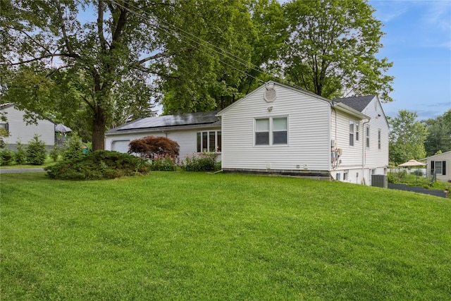 46 Laffin Ln, Poughkeepsie, NY 12603 - back of property featuring a yard, solar panels, an attached garage, and a shingled roof