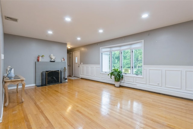 46 Laffin Ln, Poughkeepsie, NY 12603 - unfurnished living room with a decorative wall, a wainscoted wall, recessed lighting, a fireplace with flush hearth, and light wood finished floors