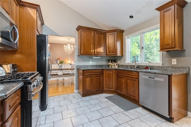 46 Laffin Ln, Poughkeepsie, NY 12603 - kitchen with stainless steel appliances, brown cabinetry, vaulted ceiling, a chandelier, and light tile patterned floors