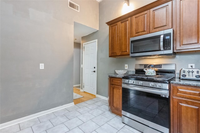 46 Laffin Ln, Poughkeepsie, NY 12603 - kitchen with appliances with stainless steel finishes, brown cabinetry, and light tile patterned floors