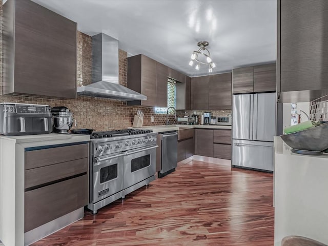 165-05 67th Ave, Fresh Meadows, NY 11365 - kitchen featuring wall chimney range hood, premium appliances, wood finished floors, light countertops, and decorative backsplash