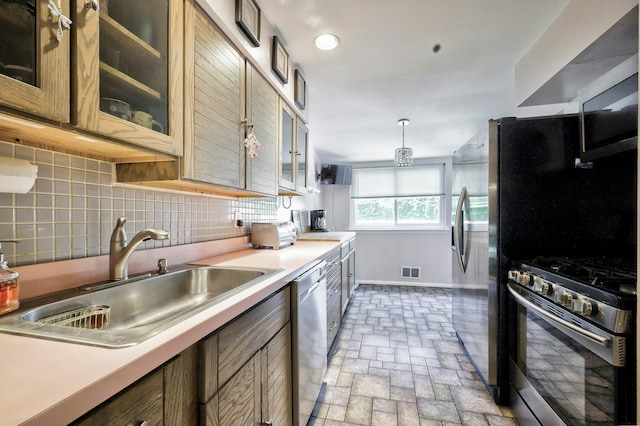 26 Comanche, Commack, NY 11725 - kitchen featuring appliances with stainless steel finishes, light countertops, tasteful backsplash, glass insert cabinets, and brick patterned floors