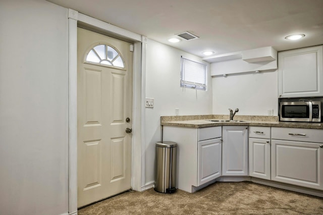 26 Comanche, Commack, NY 11725 - kitchen featuring stainless steel microwave, carpet, and white cabinetry