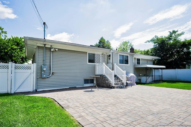 26 Comanche, Commack, NY 11725 - back of property with a gate, a patio area, and a chimney
