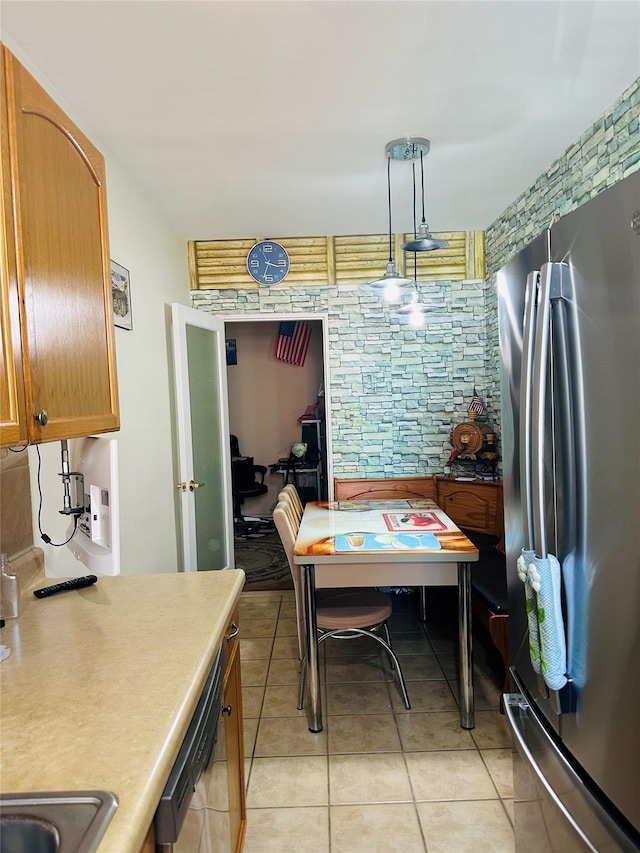 2620 E 13th St Unit 4D, Brooklyn, NY 11235 - kitchen featuring appliances with stainless steel finishes, light tile patterned floors, light countertops, decorative light fixtures, and brown cabinetry