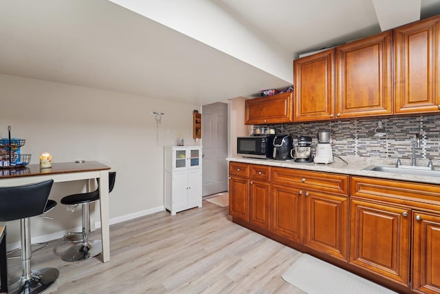 30 Birchwood Ter, Nanuet, NY 10954 - kitchen with black microwave, brown cabinets, light wood finished floors, and tasteful backsplash