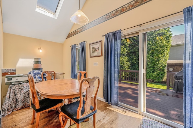 1025 Harrison Dr, Centerport, NY 11721 - dining area with light wood-style flooring, lofted ceiling, and a skylight