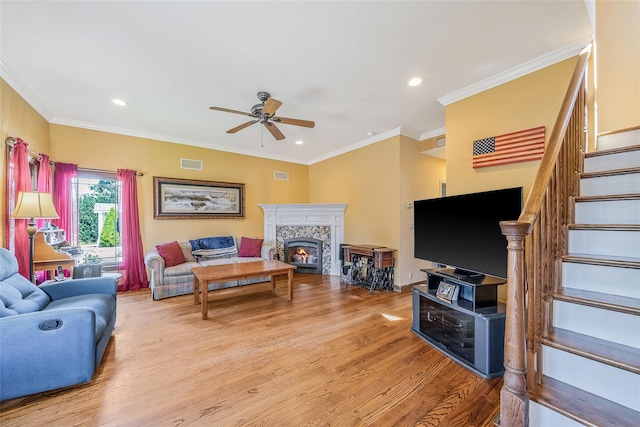 1025 Harrison Dr, Centerport, NY 11721 - living room with ceiling fan, stairway, light wood-style flooring, a warm lit fireplace, and ornamental molding