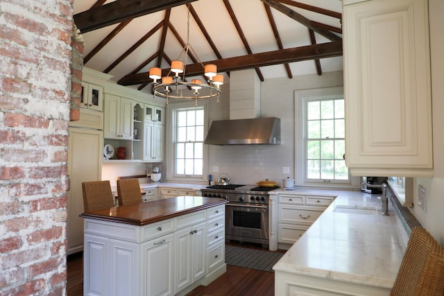 15 Abbey Crk, East Islip, NY 11730 - kitchen with stainless steel stove, a chandelier, beam ceiling, butcher block countertops, and wall chimney exhaust hood