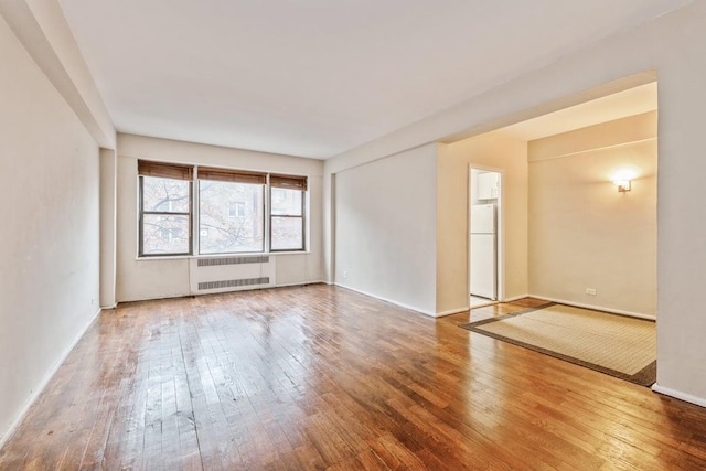 99-21 67th Rd Unit 4D, Forest Hills, NY 11375 - empty room with radiator heating unit and wood-type flooring