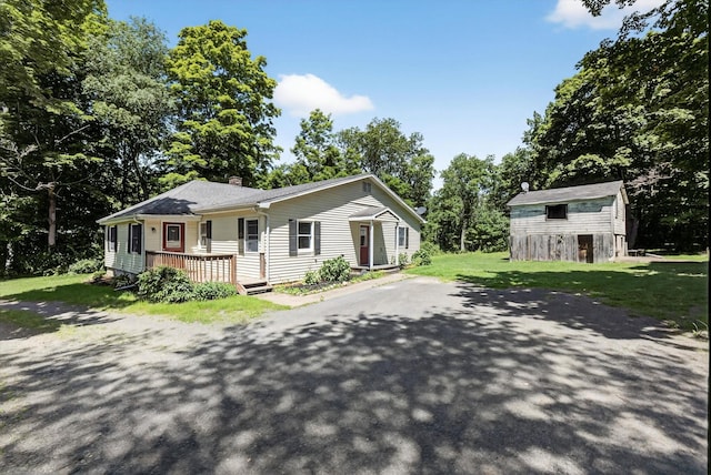 11 Tribune Ln, Red Hook, NY 12571 - view of front of house with an outbuilding, a chimney, a front yard, and view of scattered trees