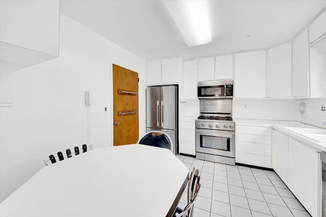 50 Chester Dr, Yonkers, NY 10710 - kitchen with appliances with stainless steel finishes, light tile patterned flooring, light countertops, white cabinets, and modern cabinets