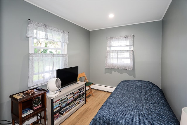 16 Primrose Ln, Levittown, NY 11756 - bedroom with baseboard heating, ornamental molding, and wood finished floors